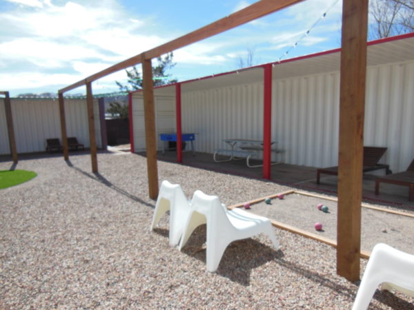 Shipping containers are used to create this covered outdoor recreation area.